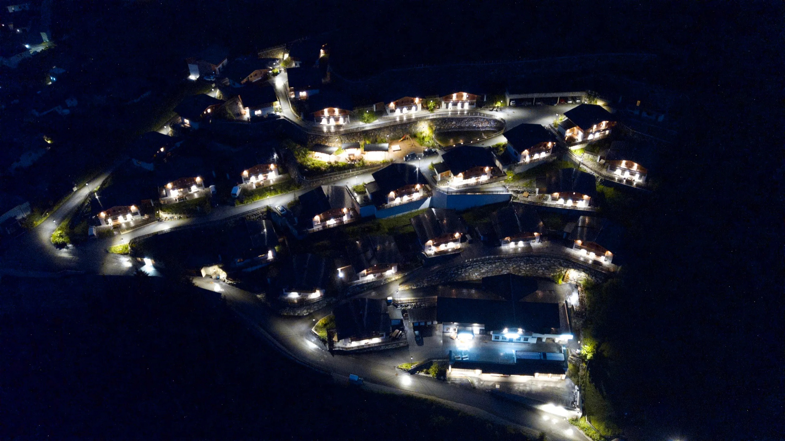 Luftbild des beleuchteten Almdorfs bei Nacht