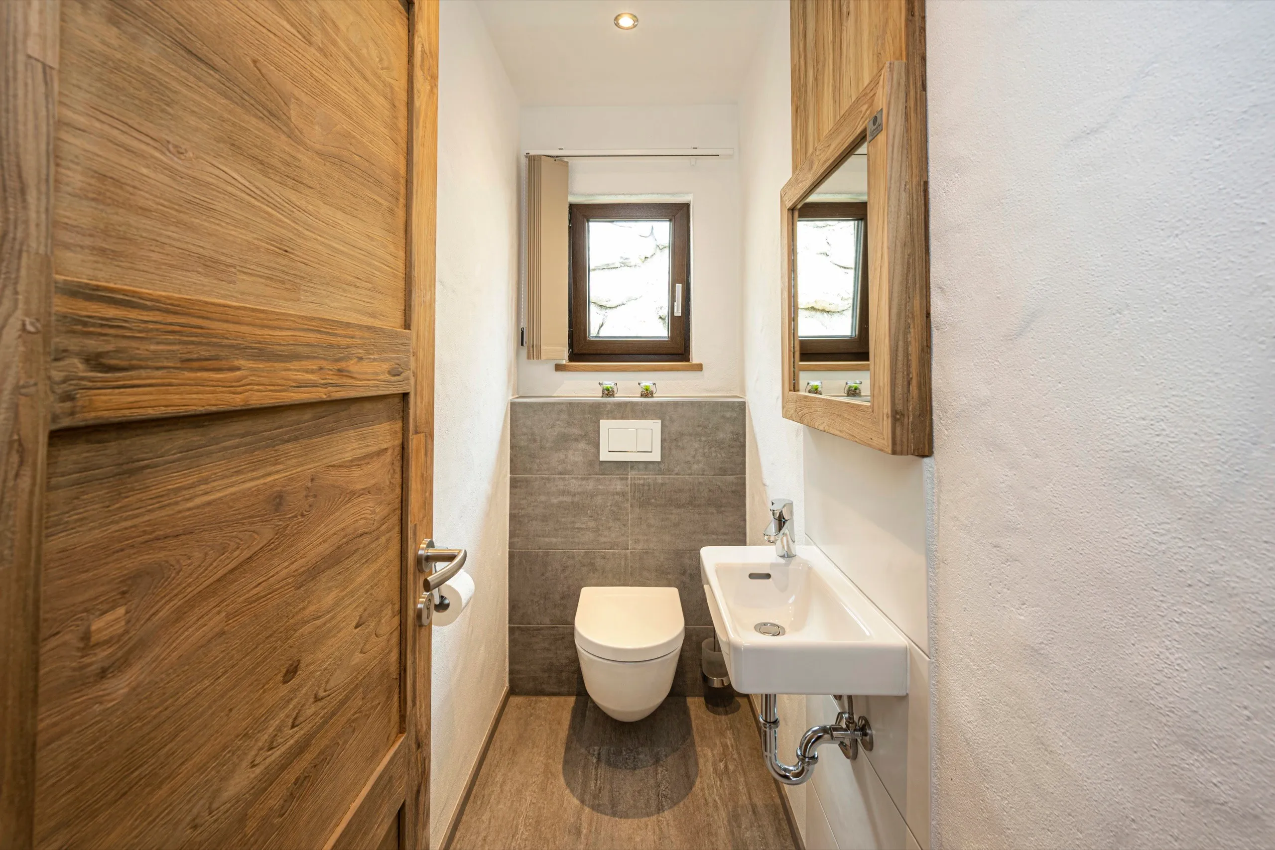 Gäste-WC mit Holztür und Waschbecken