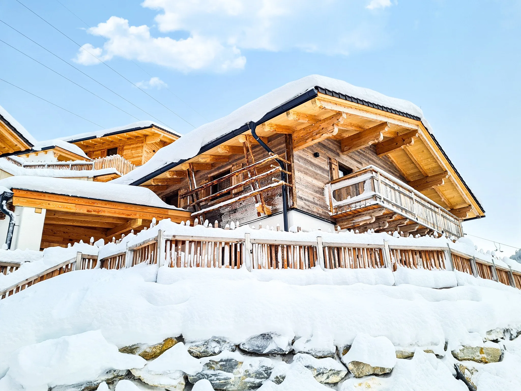 Verschneite Chalets mit Holzzäunen im Almdorf