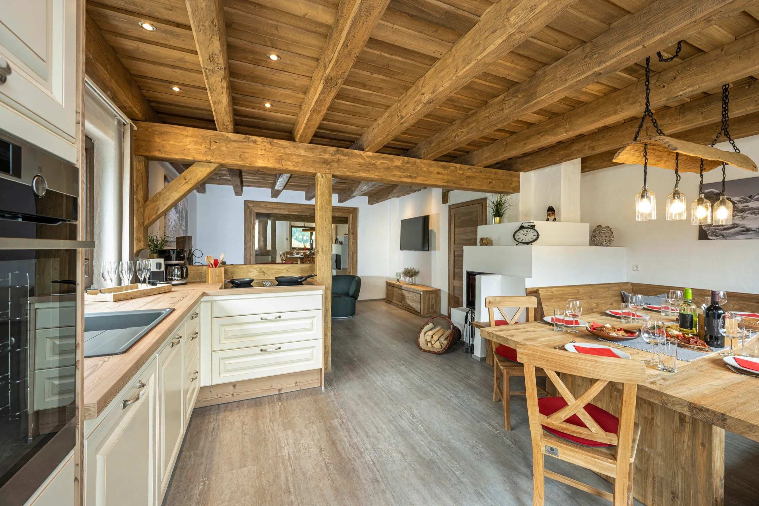 Offene Wohnküche mit Holzbalken und langem Esstisch