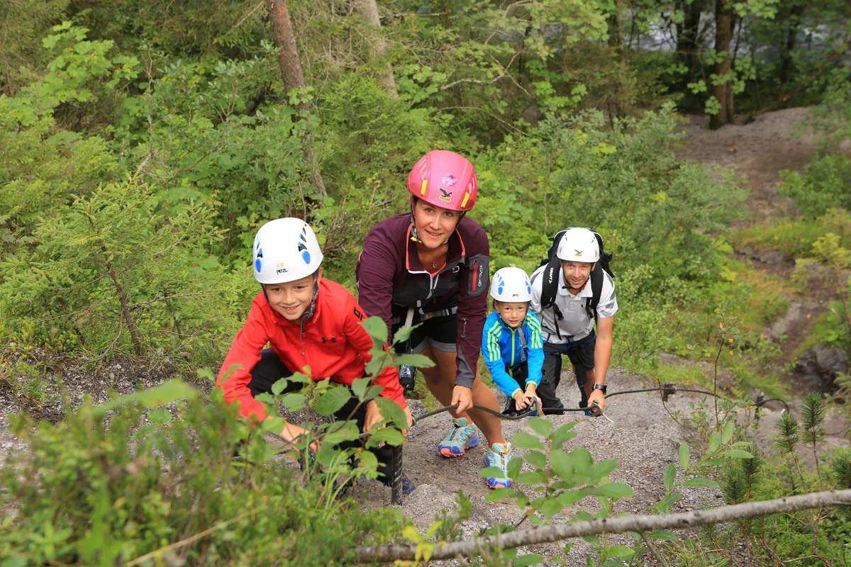 Familie mit Kletterhelmen am Klettersteig